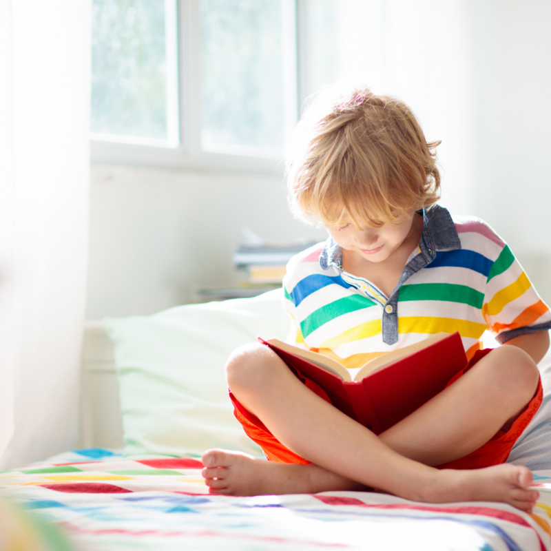Un giovane ragazzo che legge un libro a letto